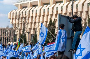 הפגנה נגד הרפורמה המשפטית מול קריית הממשלה עם דגלי ישראל ודגל הגאווה